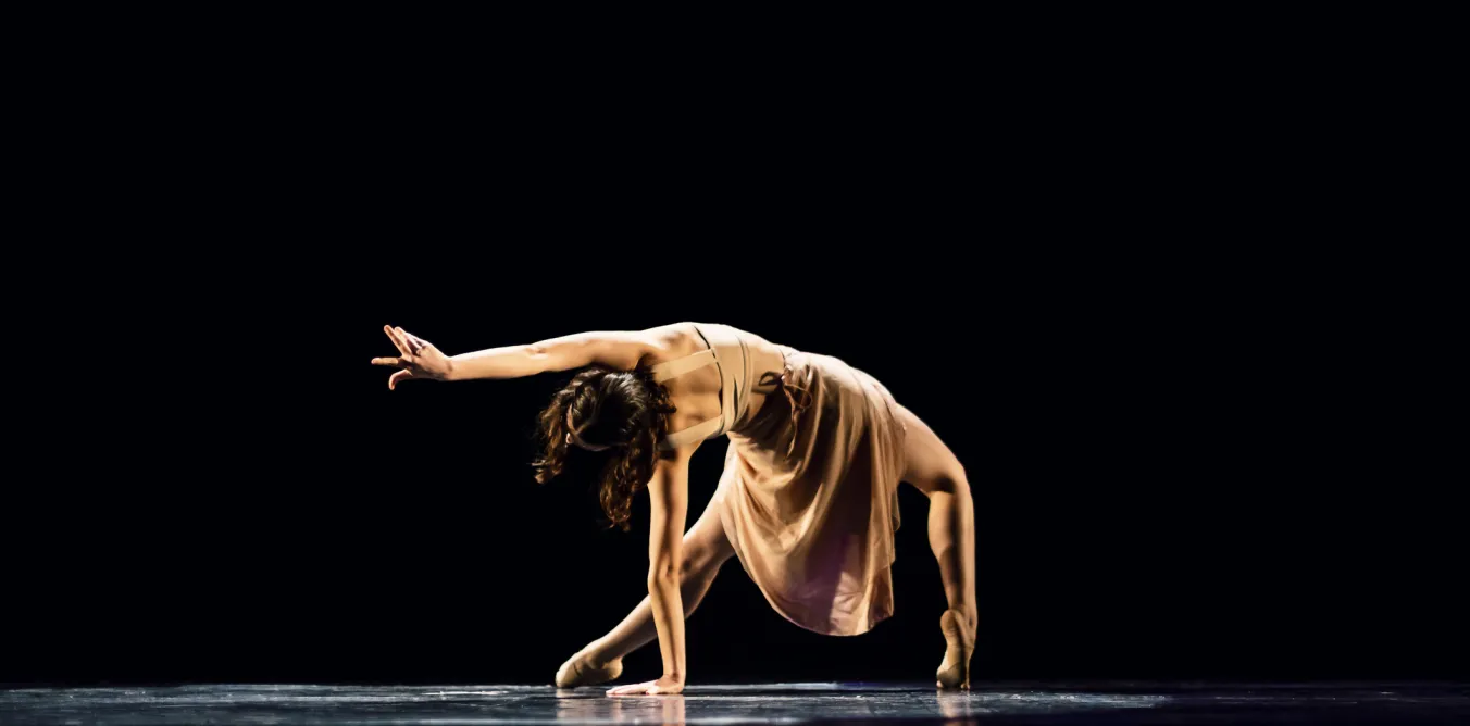 Photo of woman performing solo contemporary dance on stage