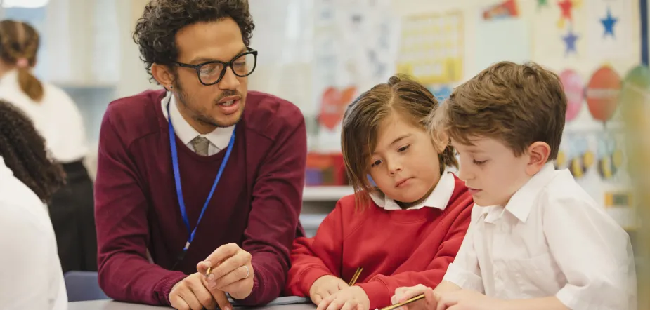 Teacher working with two young boy pupils