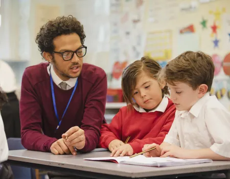 Teacher working with two young boy pupils